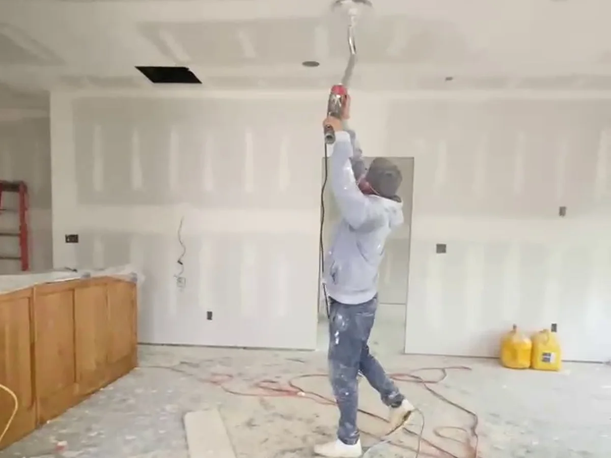 Deny sanding a ceiling smooth with a pole sander
