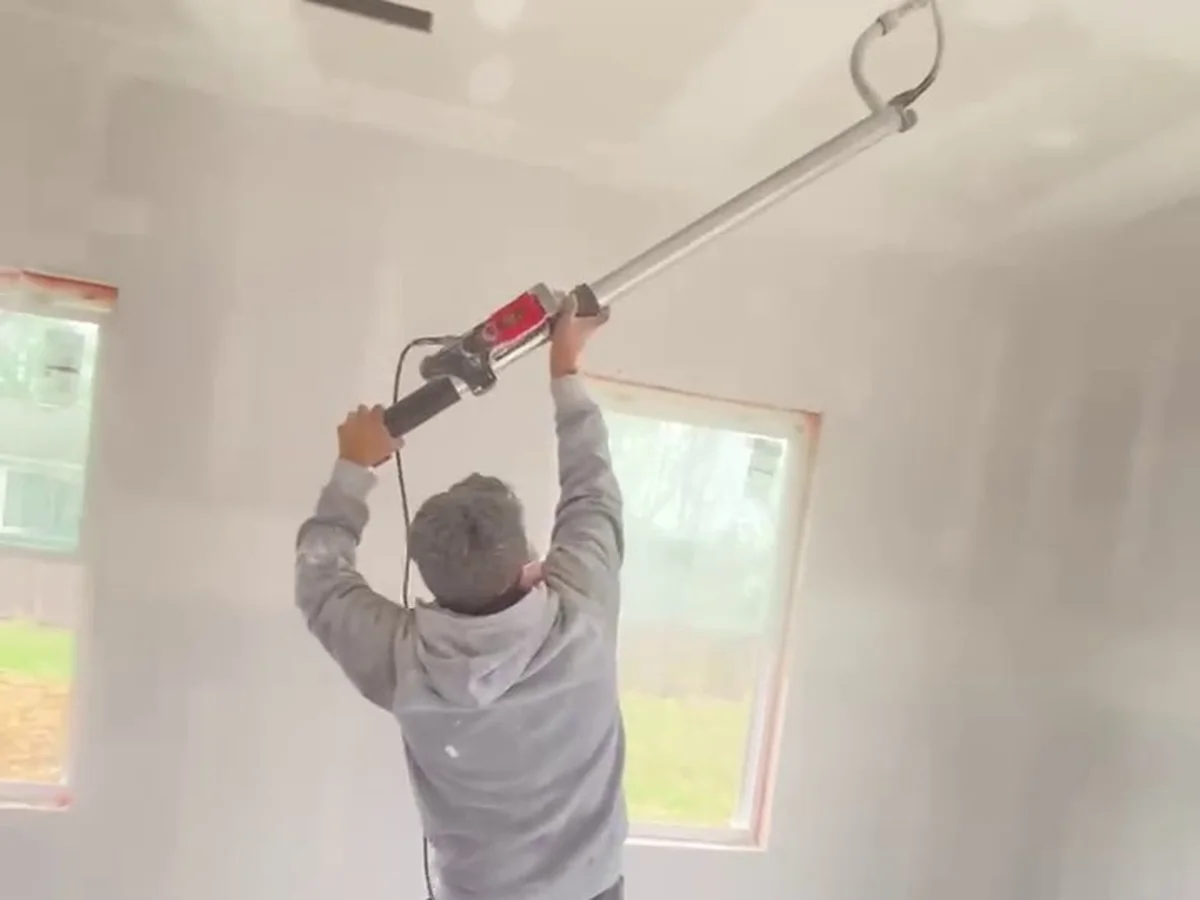 Sanding a wall seam by the window light